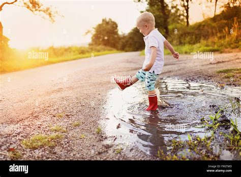 Little Boy Playing Outside In A Puddle Stock Photo Alamy