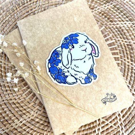 A Blue And White Rabbit Sticker Sitting On Top Of A Piece Of Brown Paper