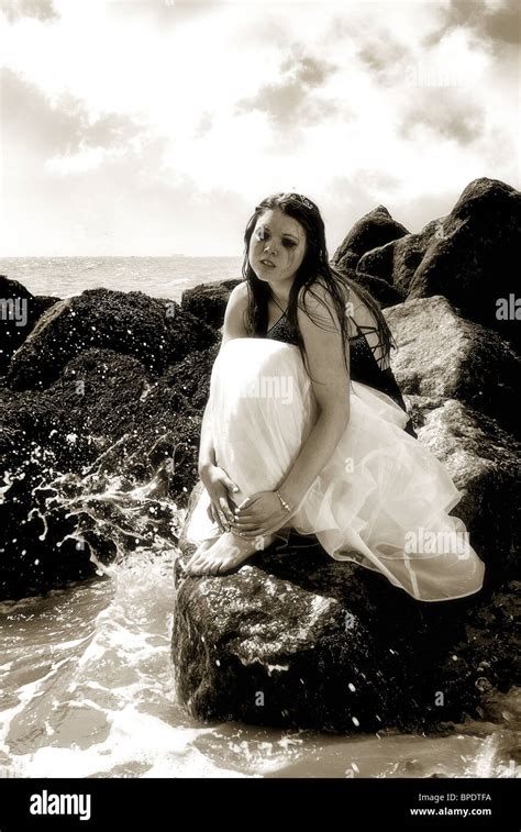 Woman In Wedding Dress Sitting On Rocks Crying Stock Photo Alamy