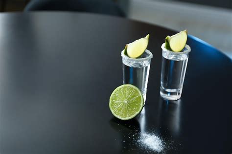 Premium Photo Mexican Tequila With Salt And Lime Slices On Black