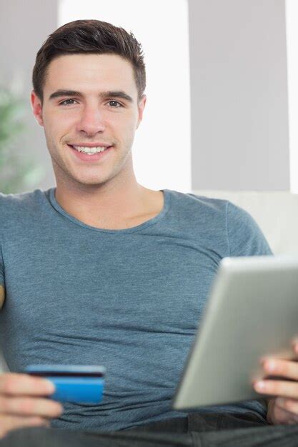 Premium Photo Cheerful Handsome Man Relaxing On Couch Using Tablet