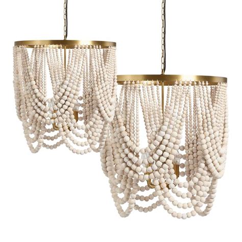 Two White Beaded Chandeliers Hanging From Chains With Gold Accents On