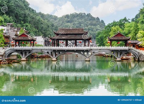 Scenic Bridge Reflected In Water Of The Tuojiang River China Stock