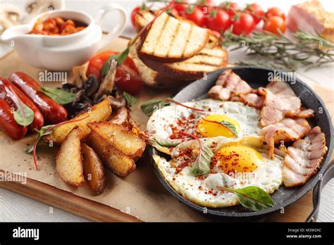 Close Up Of Rustic Full English Breakfast On A White Wooden Table Stock