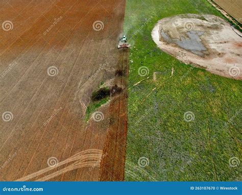 Aerial View Of A Tractor Plowing The Cultivated Farmland Stock Photo