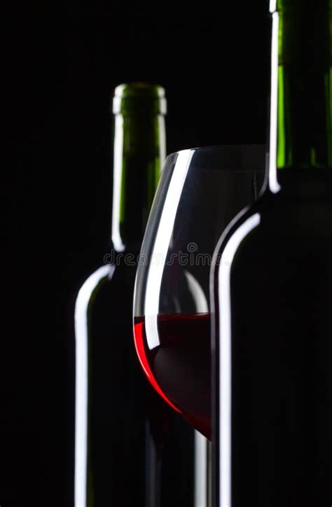 Bottles And Glass Of Red Wine On A Black Background Stock Photo