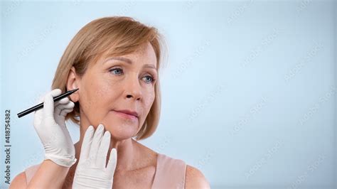 Plastic Surgeon Drawing Lines On Mature Woman S Face For Cosmetic