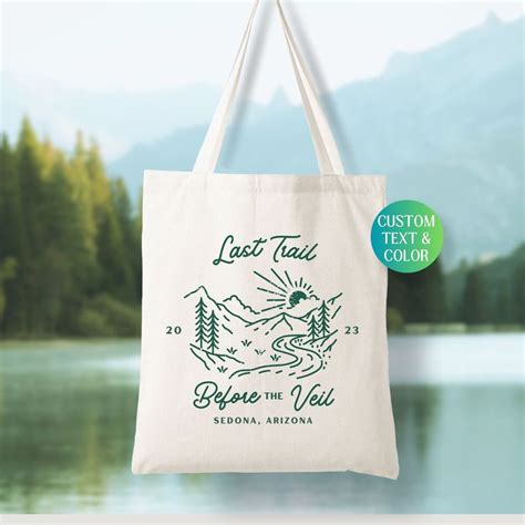 A Tote Bag With The Words Lost Trail Before The Veil In Front Of A Lake