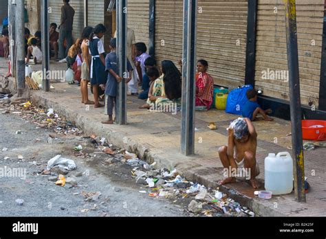 Homeless Boy Washing Himself In The Streets Of Mumbai India Stock Photo