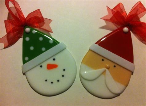 Two Decorated Christmas Cookies With Red Bows On Them One Wearing A