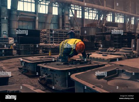 Trabajador con moldes para fundición de metal en fundición de planta