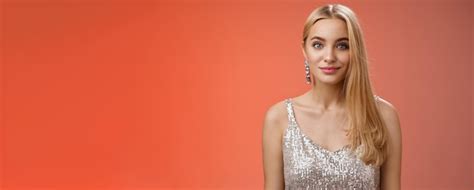 Taille amicale charmante élégante fille blonde coiffure longue en robe argentée élégante