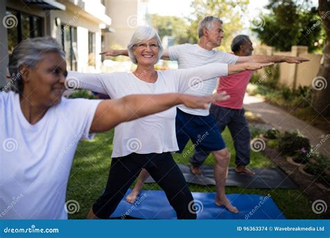 Smiling Senior Woman Exercising With Friends At Park Stock Photo