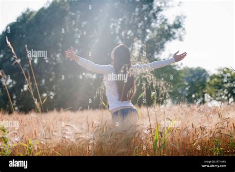 Woman With Arms Stretched Out In Wheat Field Stock Photo Alamy