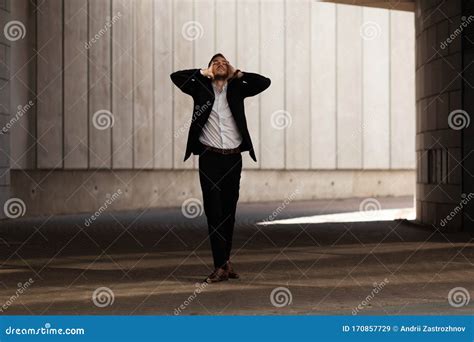 Young Businessman In Despair Holds His Hands Behind His Head In Gateway