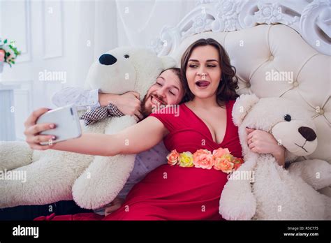 A Husband And A Pregnant Wife Make Selfie Sitting On The Couch They