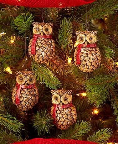 An Owl Ornament Hanging From A Christmas Tree With Red Ribbon And Pine