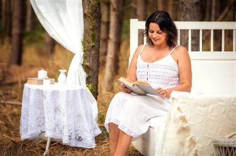 Mujer Sonriente Leyendo Un Libro En La Cama En El Bosque Foto Premium