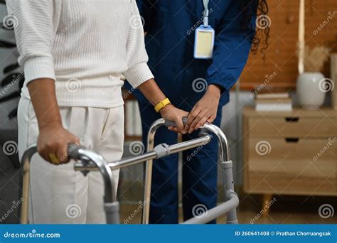 Female Caregiver Assisting Elderly Woman To Walk With Frame Elderly