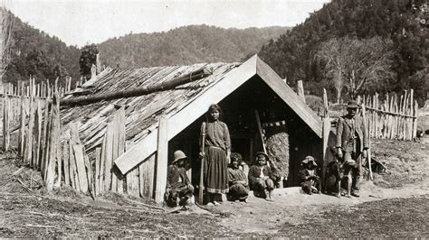 an old black and white photo of some people in front of a small hut ...