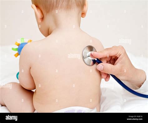 Pediatrician Examines Baby Girl Doctor Using A Stethoscope To Listen