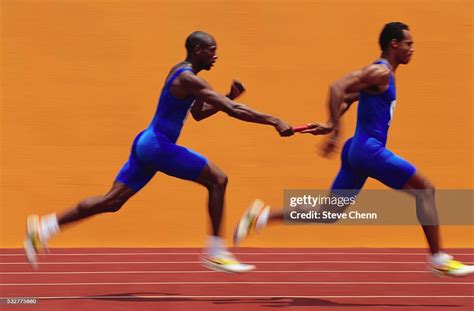 Relay Runner Passing Baton High Res Stock Photo Getty Images