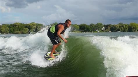 A man wake surfing behind a boat on a lake, Stock Footage | VideoHive