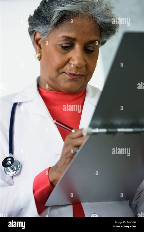 African Female Doctor Writing In Medical Chart Stock Photo Alamy