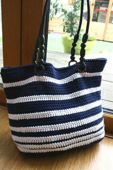 A Crocheted Purse Sitting On Top Of A Wooden Table Next To A Window