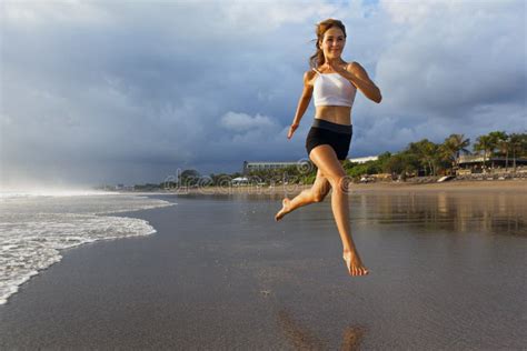 Sportflicka Som Springer Vid Strand Längs Havsytan Arkivfoto Bild av