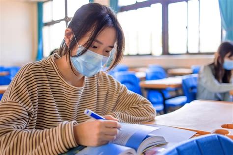 Estudiantes adolescentes que usan máscaras de protección y estudian en