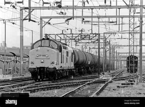 A Class 37 Diesel Locomotive Number 37891 Approaches Dagenham Dock Station With A Train Of Bogie