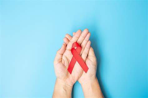 Premium Photo Man Holding Red Ribbon For Supporting People Living And