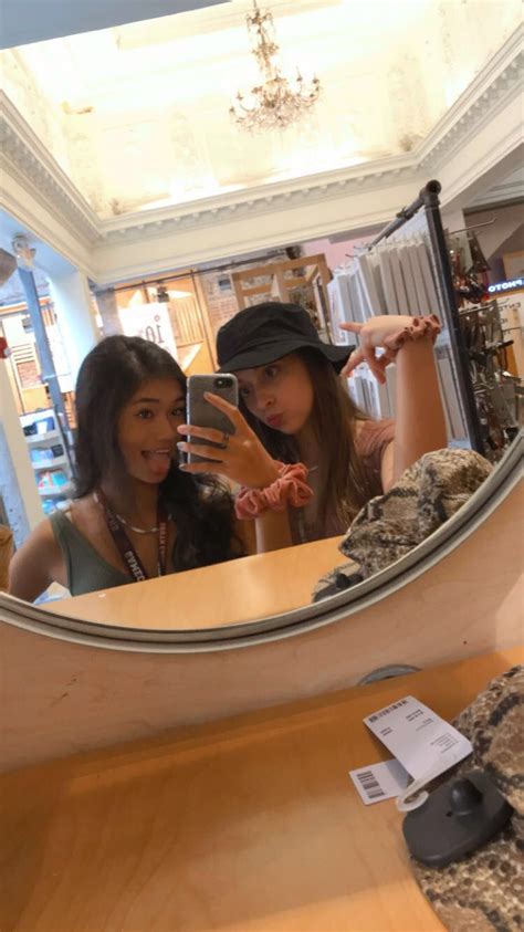 Two Women Taking A Selfie In Front Of A Mirror