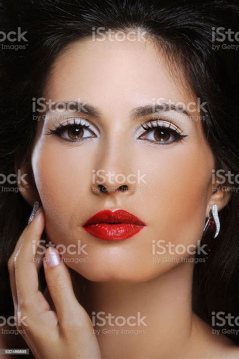 Attractive Brunette With Red Lips And Magnificent Hair Touching Face