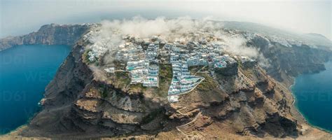 Panoramic aerial view over the clouds and bay of Santorini island ...