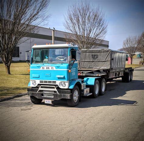 A Blue Dump Truck Is Parked On The Side Of The Road In Front Of A Building