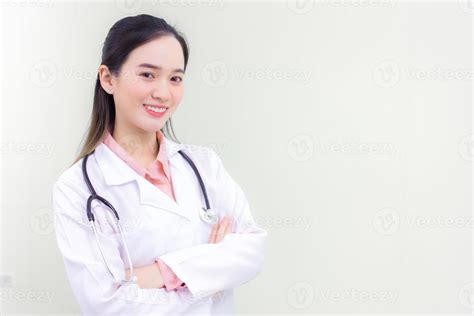 Young Beautiful Asian Woman Doctor Standing With Arms Crossed Happy And Smile In Hospital