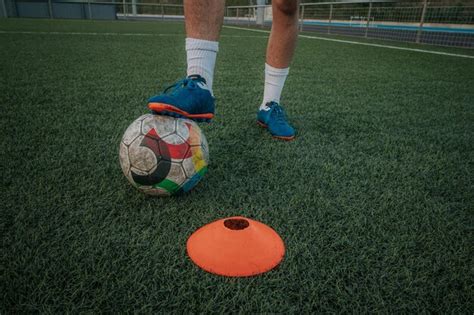 Tiro Vertical Das Pernas Do Jogador Driblando Cones No Campo De Grama