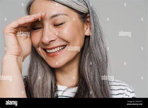 Mature White Haired Woman Laughing And Covering Her Face Isolated Over