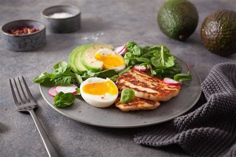 Healthy Keto Paleo Diet Breakfast Boiled Egg Avocado Halloumi Cheese Salad Leaves Stock