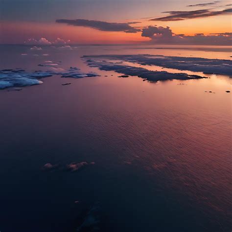 Una Puesta De Sol Con Nubes Y Un Cuerpo De Agua Con Unas Pocas Nubes En