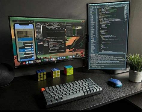 Two Computer Monitors Sitting On Top Of A Desk Next To A Keyboard