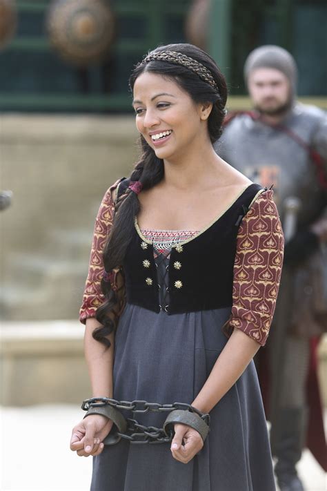 A Woman Wearing A Medieval Dress And Holding A Chain In Front Of Two