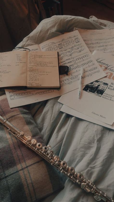 Several Pieces Of Music Sitting On Top Of A Bed Next To Sheets Of Paper