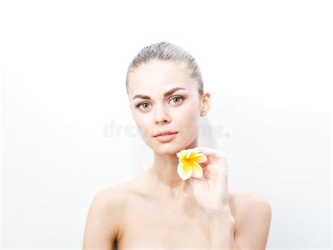 Pretty Woman With A Yellow Flower Near The Face On A Light Background Naked Shoulders Stock