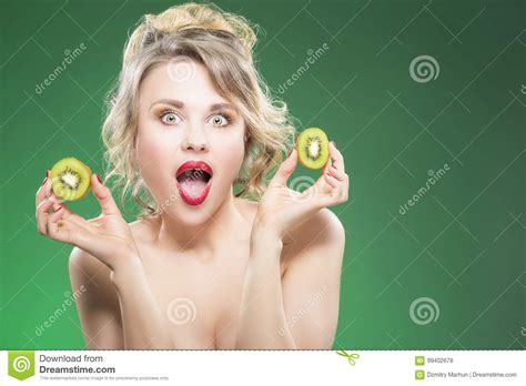 Exclaiming And Surprised Nude Caucasian Model Making Faces While Posing With Juicy Kiwi Fruit In