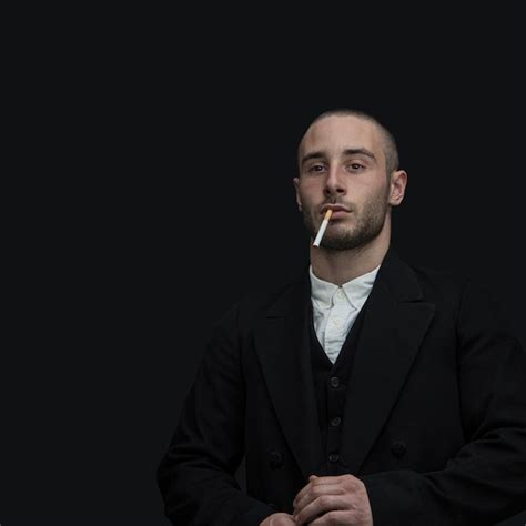 Premium Photo A Man In A Suit Smoking A Cigarette Against A Black