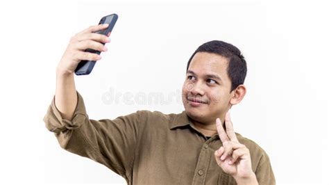 Young Asian Malay Man Smiling Takes A Selfie Portrait Picture And