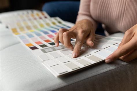 Close Up Of Young Woman Houseowner Select Interior Paint Tone Stock